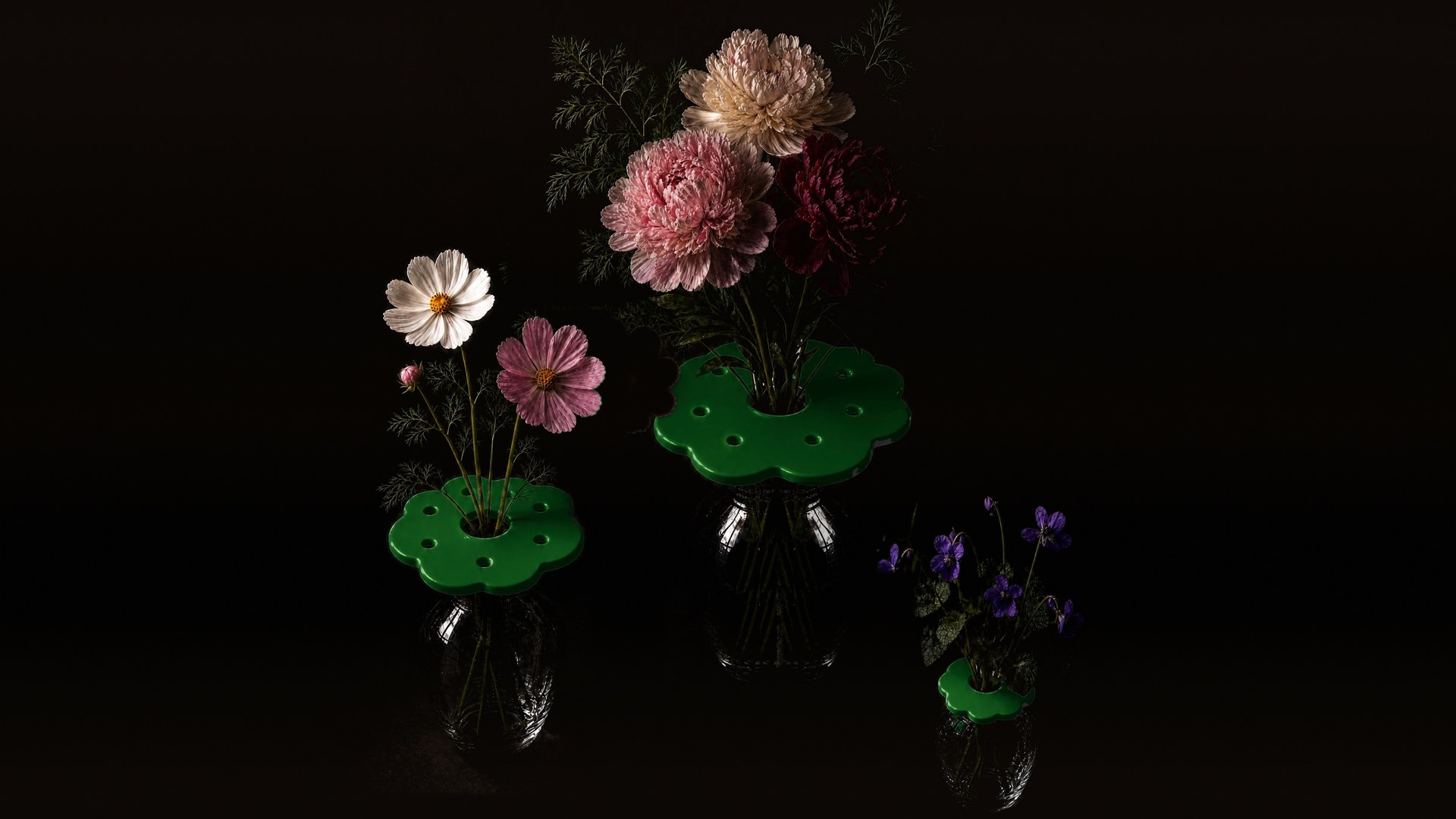 Three ceramic Flower Collars in dark green on glass vases, holding cosmos, peonies and violets
